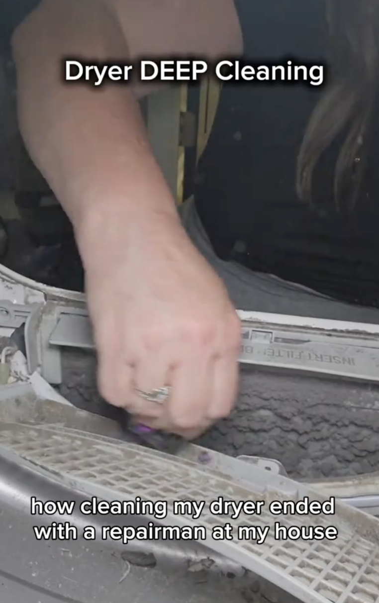 woman cleaning lint from a dryer